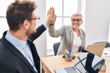 Mother and son business workers high five with hands raised up at office