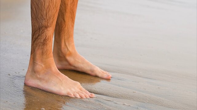 Man feet on the beach close up