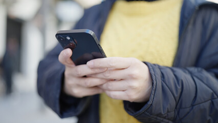 Young chinese woman using smartphone at street