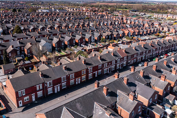 Aerial view above rows of back to back terraced houses on a large council estate