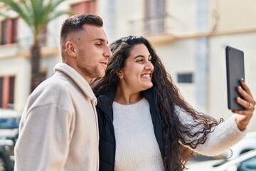 Fototapeta premium Man and woman smiling confident having video call at street