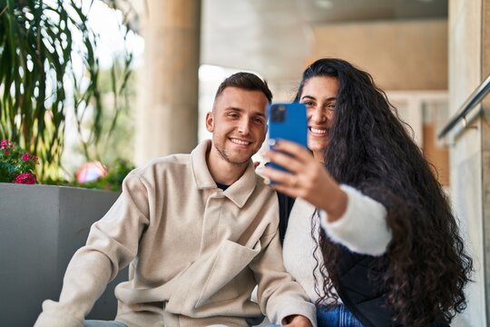 Man and woman smiling confident make selfie by the smartphone at street