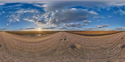 360 hdri panorama on gravel road with evening clouds on blue sky before sunset in equirectangular...