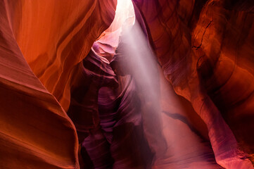 Light beams at Upper Antelope Canyon in the Navajo Reservation Page Northern Arizona. Famous slot canyon.  A vertical shot of sunlight beaming through the crack.