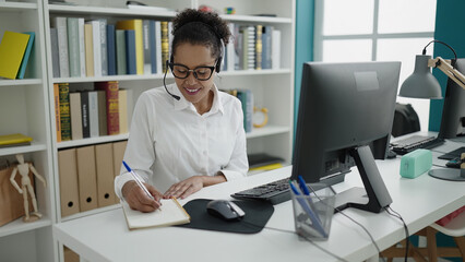 African american woman teacher having video call writing on notebook at library university