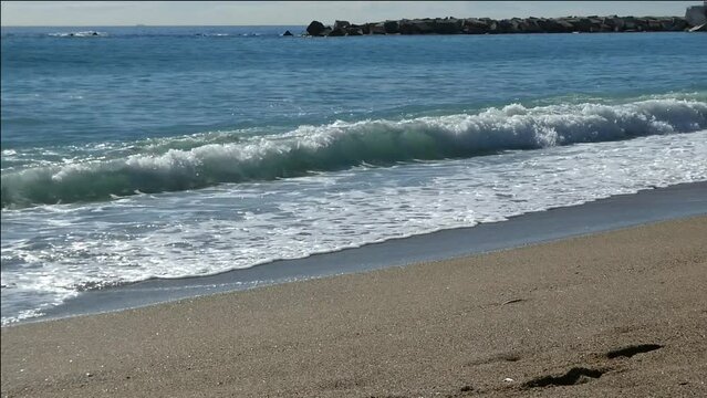 SEA WAVES BREAKING ON THE BEACH