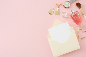 Top view photo open envelope with paper sheet perfume bottle cosmetic brushes bijouterie earrings watches on isolated pastel pink background with empty space. Women's Day atmosphere concept