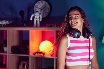 Young beautiful hispanic woman streamer smiling confident standing at gaming room