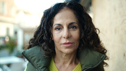 Obraz premium Middle age hispanic woman standing with relaxed expression at street