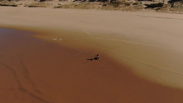 Incredible drone shot of a woman is bathed by sunlight and washed by positive ocean ions