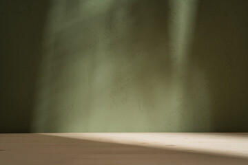 Podium wooden table on dark green background with gradient leaf shadow on the wall. Mock up for...