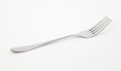 Metal fork lying on a white background. Front view.