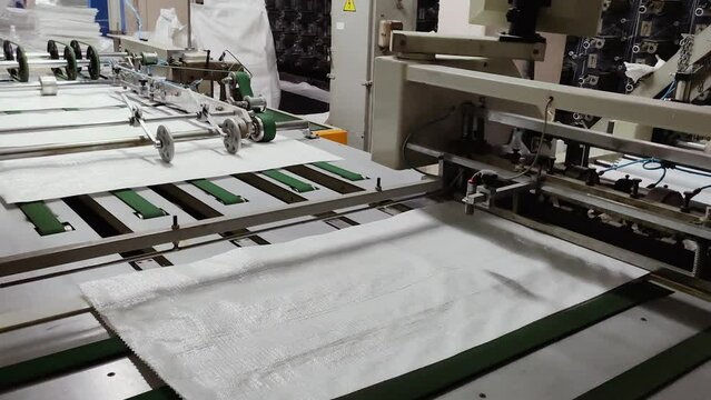 Enterprise for the production of polypropylene bags. Polypropylene fabric is cut to the desired size on a cutting machine