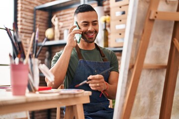 African american man artist talking on smartphone drawing at art studio