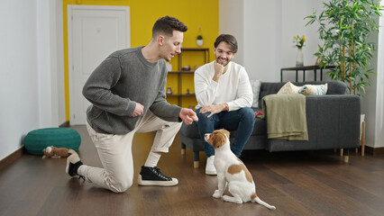 Two men couple training dog at home
