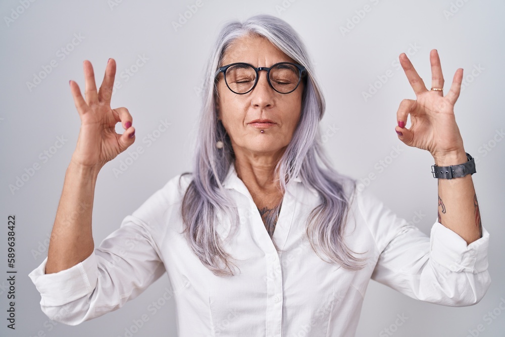 Wall mural middle age woman with tattoos wearing glasses standing over white background relax and smiling with 