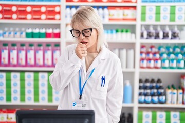 Young caucasian woman working at pharmacy drugstore feeling unwell and coughing as symptom for cold or bronchitis. health care concept.