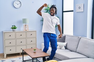 African american woman listening to music and dancing at home