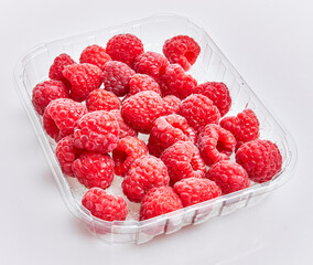  Delicious group of raspberries on plastic box over isolated white background