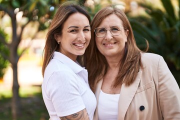 Mother and daughter smiling confident hugging each other at park