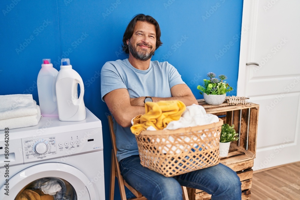 Sticker handsome middle age man waiting for laundry happy face smiling with crossed arms looking at the came