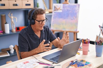 Middle age man artist having video call at art studio