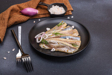 Fillet of pickled marinated sea herring fish with shallots and dill. Cutlery, vintage napkin
