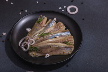 Fillet of pickled marinated sea herring fish with shallots and dill. Served ready to eat seafood