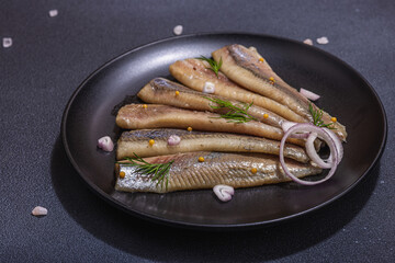 Fillet of pickled marinated sea herring fish with shallots and dill. Served ready to eat seafood