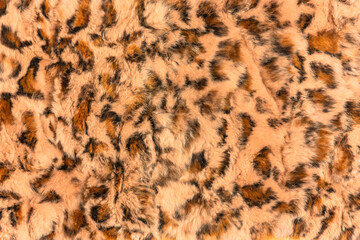 A synthetic material resembling long animal hair has been used to create a highly intricate background texture that mimics the appearance of leopard fur.
