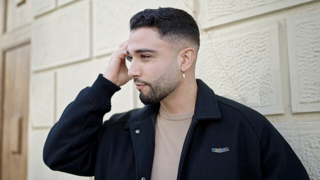 Young arab man smiling confident listening audio message by the smartphone at street