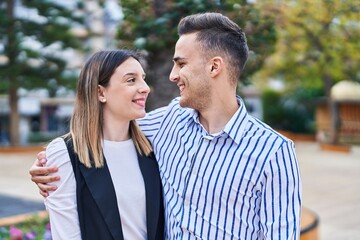 Fototapeta premium Man and woman couple smiling confident hugging each other at park