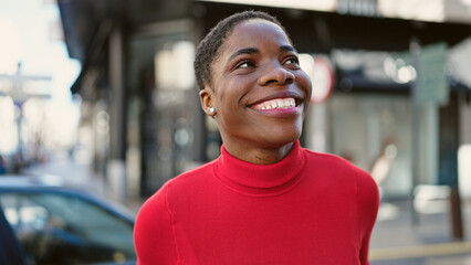 Fototapeta premium African american woman smiling confident looking to the sky at street
