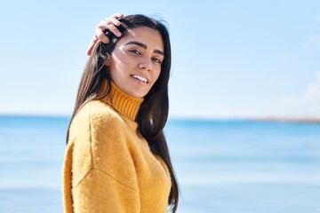 Young hispanic woman smiling confident standing at seaside