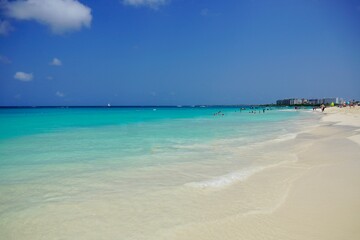 Fototapeta na wymiar The miles of white sand and clear turquoise water of Eagle Beach in Aruba
