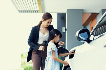 Progressive lifestyle of mother and daughter who have just returned from school in an electric...