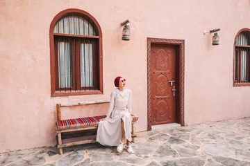 Photo sur Plexiglas Abu Dhabi Happy asian girl in headscarf walking at old town or heritage village in UAE