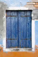 Obraz na płótnie Canvas faded old rustic blue door on the island of Burano near Venice traditional fishing village colours sunlight fade tourism Venetian islands, Italy