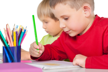 Two little boys studying math at class with green chalk board on background
