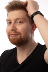 Obraz premium Studio head shot portrait of a handsome caucasian man in his 20s. He is wearing a black shirt and has strawberry blonde hair and a beard. He has blue eyes. 