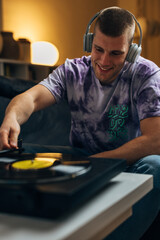 A happy man is listening to his records alone using headset