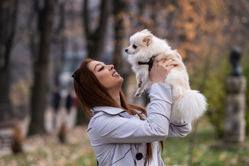 A young woman is playing with a dog