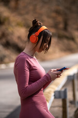 A young woman listens to music on wireless headphones