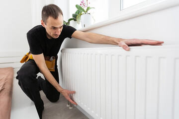Repair heating radiator close-up. man repairing radiator with wrench. Removing air from the radiator