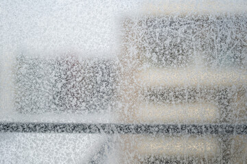 frost forming a pattern  on a window in a freezing temperature in winter