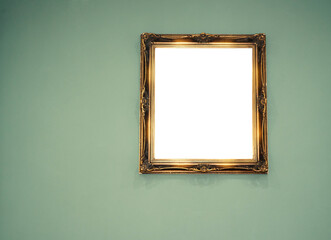 Goldener, barocker Bilderrahmen mit Platz für ein Bild an einer grünen Wand hängend