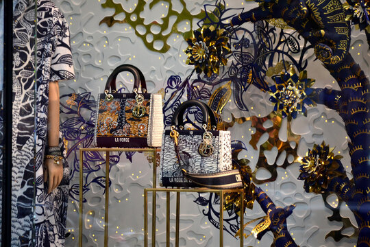 Paris, France - October 24th 2019 : Shop window of Dior for winter, in a style close to the modern tapestry of Jean Lur&ccedil;at. Focus on bags designed like tarot of Marseille cards.
