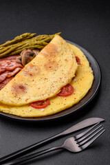 Delicious fresh omelet with cherry tomatoes, bacon, asparagus and spices