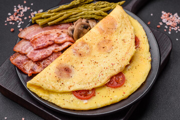 Delicious fresh omelet with cherry tomatoes, bacon, asparagus and spices