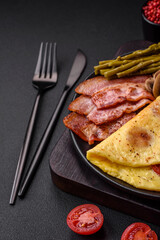 Delicious fresh omelet with cherry tomatoes, bacon, asparagus and spices